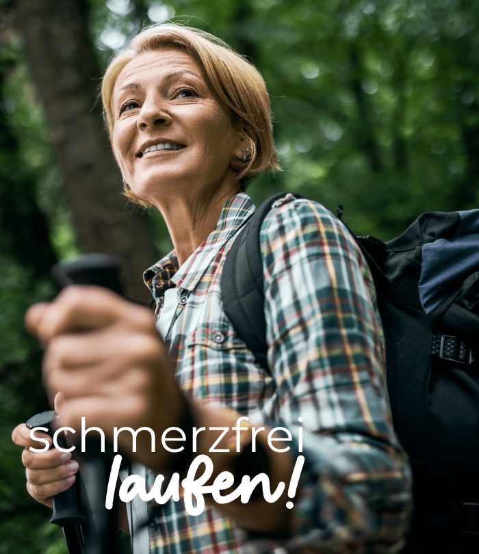 Eine blonde ältere Frau mit kurzem Haar und kariertem Hemd, trägt einen Wanderrucksack und hält Wanderstöcke in der Hand. Der Wald im Hintergrund ist verschwommen. Auf dem Bild steht "schmerzfrei laufen!".